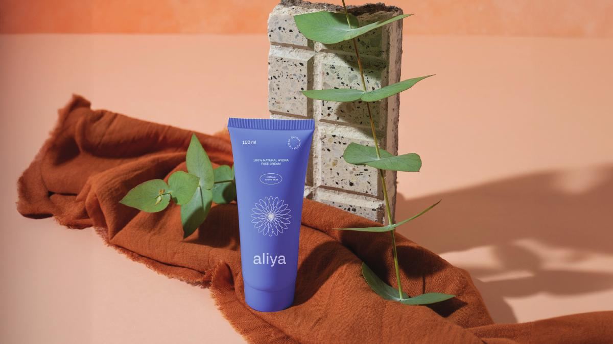 Aliya Skin product photography · tube styled on orange fabric