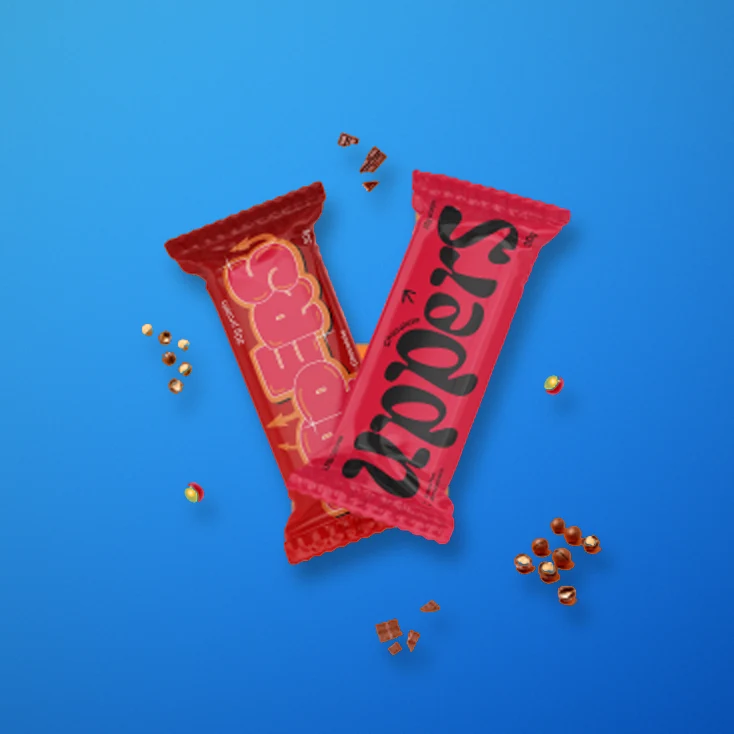Two Uppers bars crossed on a blue backdrop with chocolate crumbs
